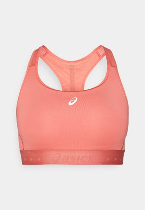 Koronkowy stanik sportowy w kolorze koralowym z wycięciem na plecach, wykonany z elastycznego materiału. Posiada gładką teksturę oraz wytłoczone logo Asics na pasku.