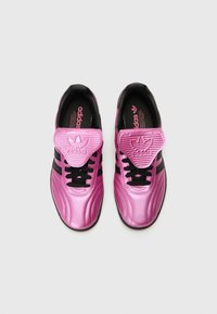 Rosa satinsneakers med svarta detaljer och snörning. Har en texturerad tunga och tre svarta ränder på sidorna. Gummisula ingår.