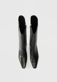 Hohe schwarze Lederstiefel mit eckigen Zehen und Seitenzippern, aufrecht auf einem schlichten weißen Hintergrund.