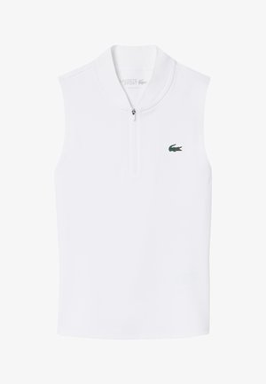 Polo blanco sin mangas con cremallera, con un pequeño logo verde de cocodrilo de Lacoste en el pecho izquierdo.