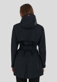 Giacca impermeabile navy con vita regolabile, cappuccio ampio e ventola posteriore per la circolazione dell'aria. Presenta un logo rosso sul cappuccio.