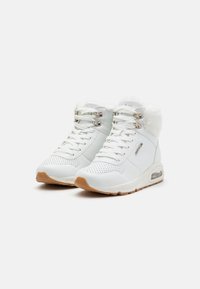 Sneaker alte bianche realizzate in materiale sintetico con foderatura in pelliccia, suola in gomma e occhielli metallici. Presentano dettagli traforati e sistema di ammortizzazione.