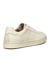 Sneaker in pelle beige con finitura liscia, punta rotonda, dettagli in suede texture e suola in gomma; presenta lacci piatti e un branding discreto.