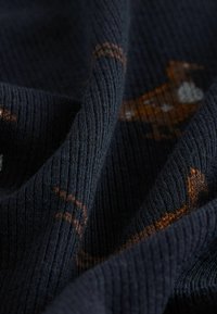 Navy knit fabric with a textured ribbed pattern, featuring brown and orange animal designs woven throughout. Soft and slightly stretchable.