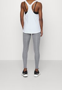 Light blue tank top with a racerback design, paired with gray leggings. The tank features thin straps and a straight hem, while the leggings have a smooth texture.