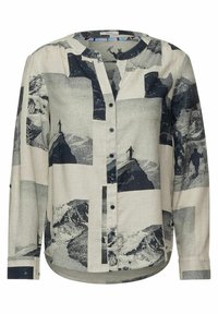 Camicia a maniche lunghe con bottoni in tessuto beige chiaro, caratterizzata da una stampa grafica di montagne in blu scuro, con scollatura rotonda e orlo arrotondato.