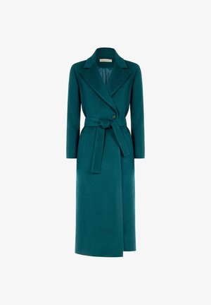 Manteau long teal en tissu texturé, avec un design enveloppant, des manches longues, deux poches latérales et une ceinture assortie à la taille.