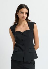 Schwarze ärmellose Jacke mit einem quadratischen Ausschnitt, fünf Knöpfen und zwei Fronttaschen, mit taillierter Passform und glatter Textur.