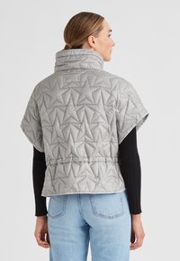 Hellgraue, gesteppten Puffer-Weste mit hohem Kragen, kurzen Ärmeln und sternförmigen Nähten. Mit einem verstellbaren Taillenbund.