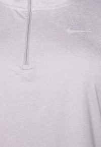 Hellblaues Nike Sportoberteil mit einem Viertel-Reißverschluss, glatter Textur und kleinem grauen Logo auf der Brust.