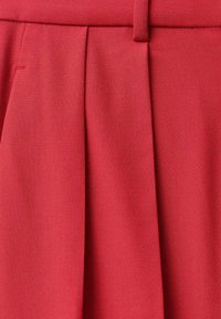 Pantalon rouge sur mesure avec pli devant et passant de ceinture, en tissu tissé lisse.