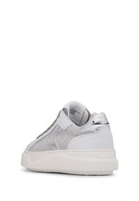 Sneaker bianco con inserti in rete e dettagli argentati, caratterizzato da una suola spessa e testurizzata e una forma arrotondata. I dettagli metallici arricchiscono il design.