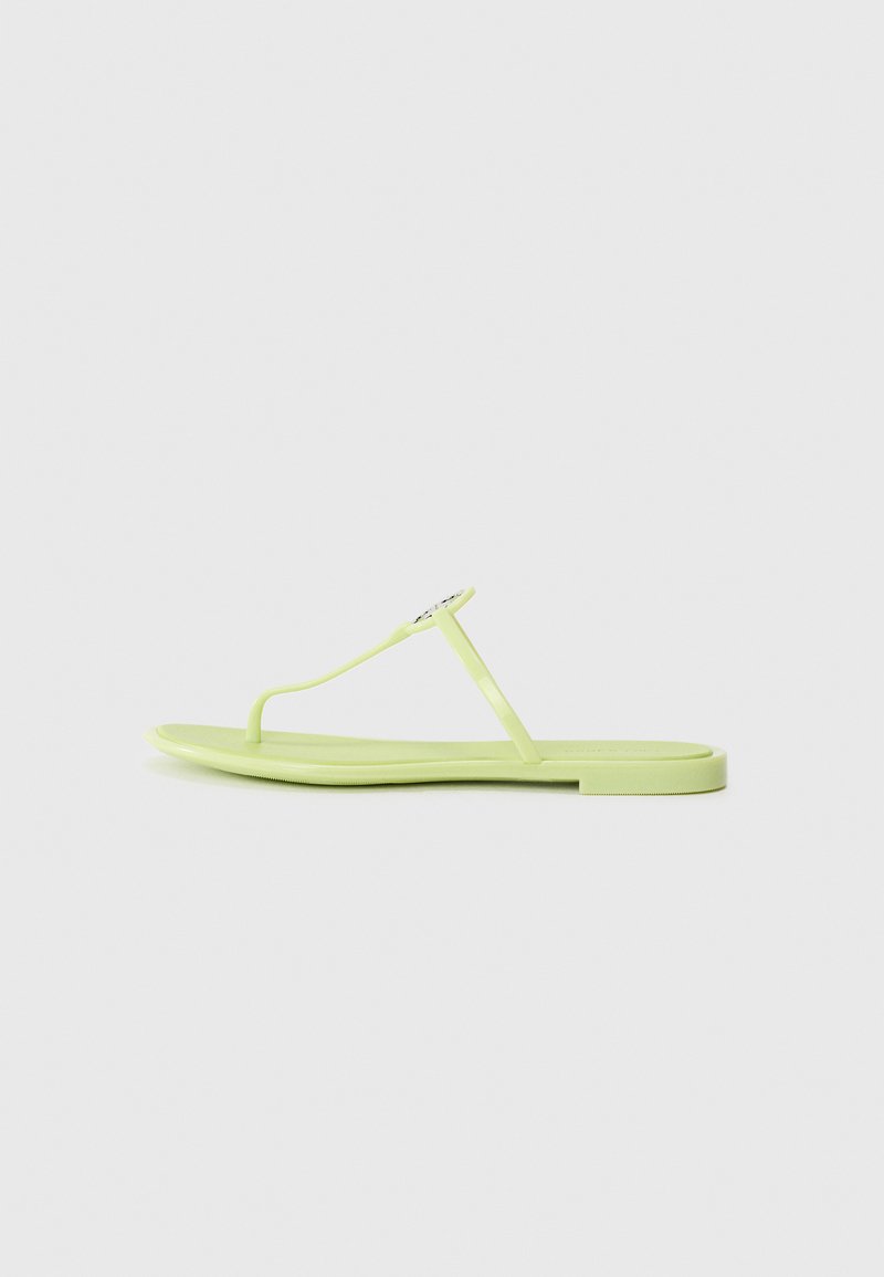 Ploski thong sandal v svetlozeleni plastiki, ki se ponaša z minimalističnim dizajnom, ozkimi trakovi in majhnim dekorativnim naglasom na zgornjem traku.