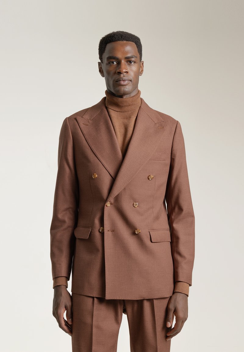 Blazer marrón a medida de doble botonadura, fabricado en tejido texturizado, que presenta cuatro botones, un bolsillo en el pecho y solapas afiladas.