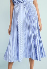 Plisowana spódnica w jasno-niebieskie i białe pionowe paski, wykonana z lekkiego materiału, z wiązaniem w talii.