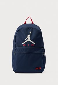 Σακίδιο πλάτης σε ναυτικό μπλε με κόκκινες λεπτομέρειες, με κεντημένο λευκό λογότυπο «Air» και Jumpman. Διαθέτει μπροστινή τσέπη με φερμουάρ. Ανθεκτικό ύφασμα.