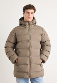 Pufferjack in taupe, met een capuchon, ritsluiting en elastische manchetten. Het ontwerp heeft horizontale stiksels en zijzakken.