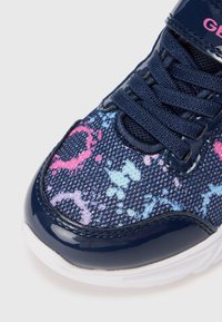 Niebieski siatkowy sneaker z kolorowym wzorem rozprysków, granatowymi akcentami z lakierowanej skóry, białą gumową podeszwą oraz pasującymi niebieskimi sznurówkami.