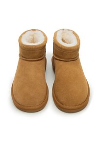 Stivaletti alla caviglia in suede marrone con morbida fodera in pelliccia sintetica bianca, punta tonda e dettagli cuciti sul bordo superiore. Suola piatta in gomma.