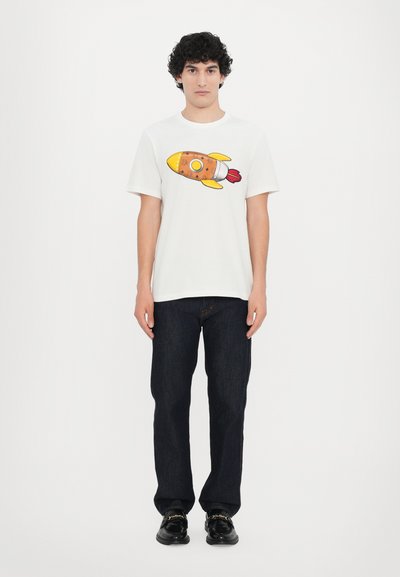 White t-shirt featuring a cartoon rocket design in orange and yellow, paired with dark blue jeans and black shoes. Simple, casual outfit.