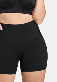 Hoge zwarte shorts gemaakt van een gladde, rekbare stof, met een naadloos ontwerp en een elastische tailleband voor comfort.