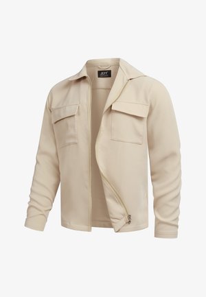 Beige lynlåstrøje med to brystlommer med klap, lange ærmer og krave, let åbnet lynlås på hvid baggrund.