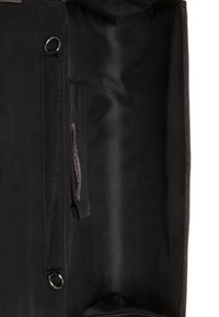 Czarna tkanina wewnętrzna torby z boczną kieszonką, srebrnym, okrągłym okuciem oraz metką z napisem 'ANNA FIELDS' w fioletowym kolorze.