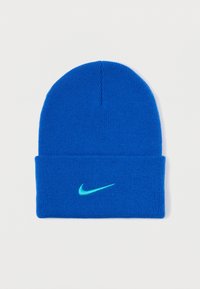 Μπλε πλεκτή σκούφια με αναδιπλούμενη πατούρα, με χαρακτηριστικό το νεον τουρκουάζ λογότυπο Nike στη μπροστινή πλευρά. Φτιαγμένη από μαλακό, υφασμάτινο υλικό.