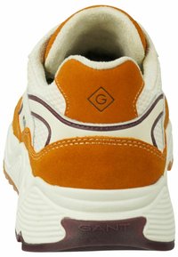 Sneaker mit einem Obermaterial aus weißem Mesh und orangefarbenem Wildleder, mit runder Schuhlasche, lila Akzenten und einer strukturierten weißen Gummisohle.