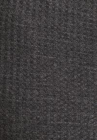 Geripptes Strickgewebe in Dunkelgrau mit vertikalen Linien und einer weichen Textur, geeignet für Bekleidung oder Accessoires.