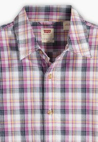 Camicia a quadri nei toni di rosa, viola e giallo con dettagli in bianco e nero. Vestibilità slim, con colletto e chiusura con bottoni.