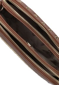 Interieur van een bruine synthetische leren tas met twee ritssluitingen, gouden ritsen en zilveren studs aan de buitenzijde. Gladde, strakke textuur.