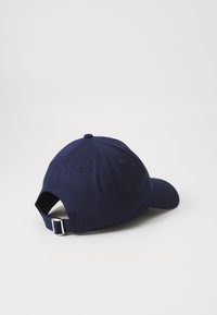 Sötétkék baseball sapka ívelt karimával, puha pamut anyagból, hátul állítható pánttal és öt varrt szellőzőnyílással.