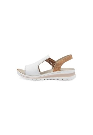 White leather sandal featuring a cork back accent, open sides, and a lightweight white sole with a soft texture and subtle sheen.
