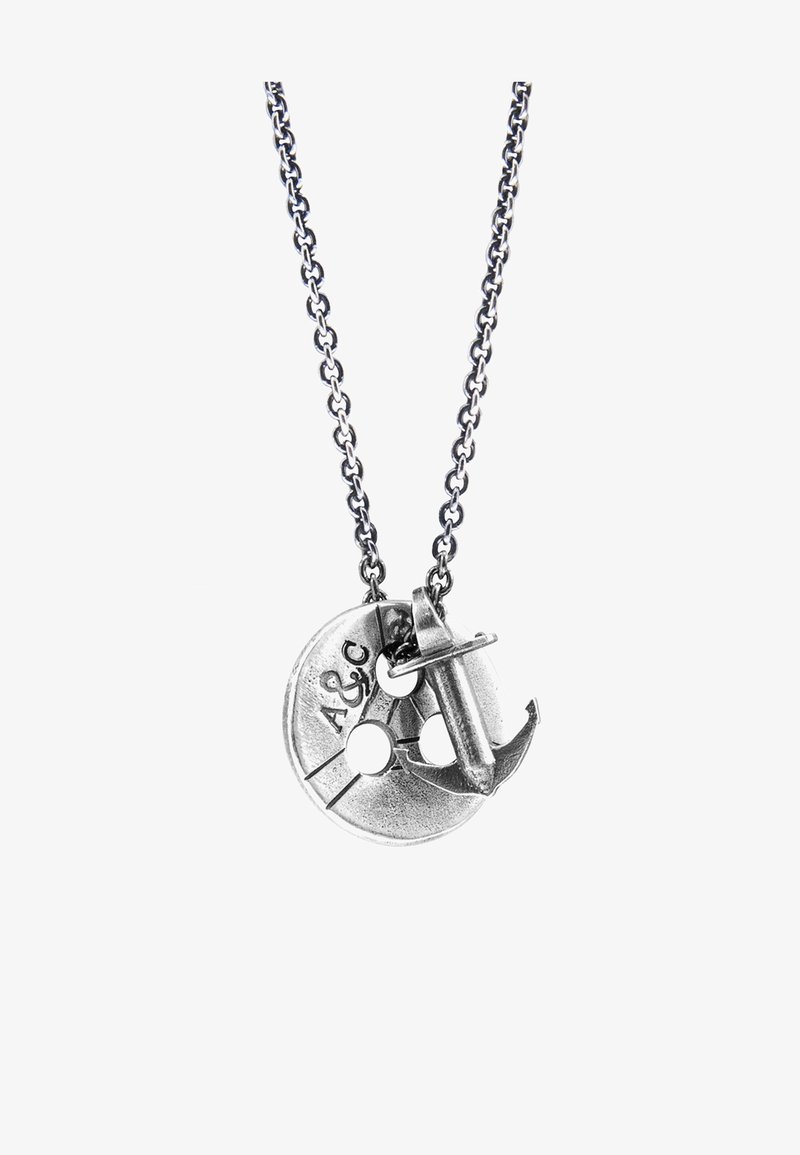 Silver-tone necklace featuring a circular pendant with two holes, engraved markings, and an anchor charm attached to the pendant.