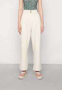 Crème-kleurige wijde broek met een hoge taille, voorzien van een dubbele knoopsluiting, zachte textuur en minimalistisch ontwerp.