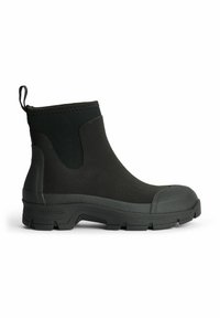 Botas de tobillo de goma negra con paneles laterales texturizados, punta redondeada y tirador. Presenta una suela con patrón para mayor tracción.