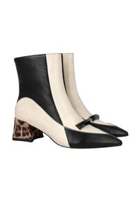 Botas de tobillo de cuero negro y crema con puntas afiladas, detalle de lazo negro y tacón cuadrado con estampado de leopardo. Textura suave con colores en contraste.