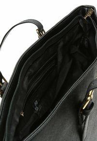 Interno di una borsa nera con più scomparti, texture in tessuto, chiusure con zip e finitura liscia. Accenti in oro sulle cinghie.