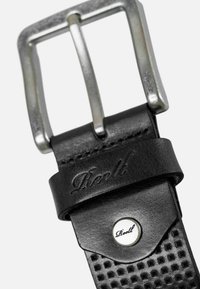 Cinturón de cuero negro con un acabado mate, que presenta una hebilla de metal plateado, un logo estampado y una correa texturizada con pequeñas perforaciones.