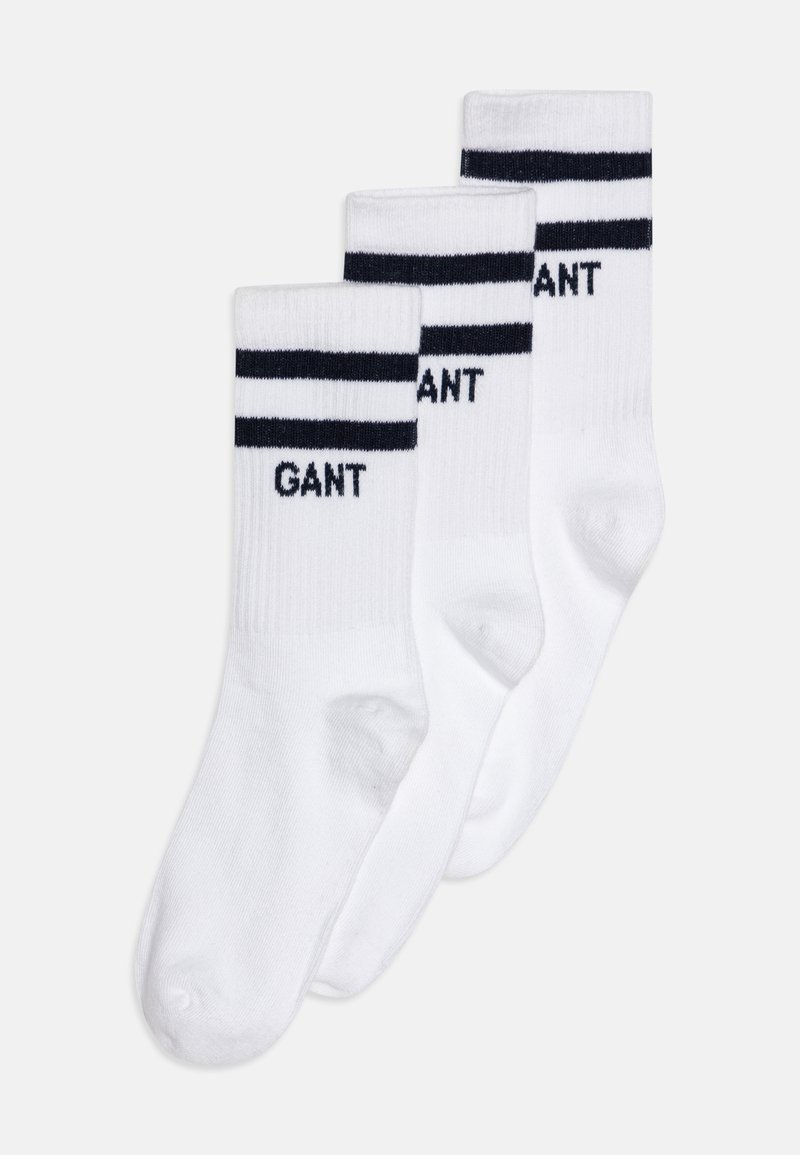 Vita bomullssockor med marinblå ränder, med "GANT"-logotyp i marinblå text. Tre par visas, vilket visar ribbat mönster och medellång längd.