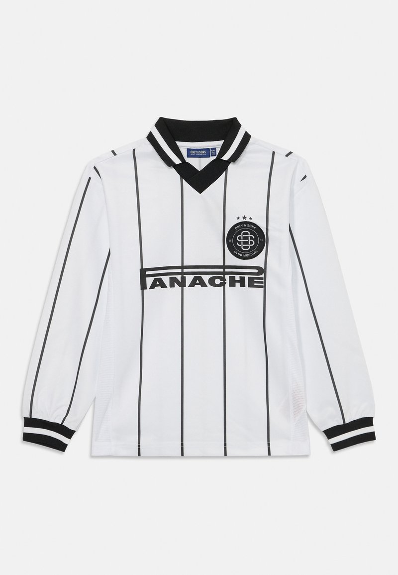 Valge pika varrukaga jerser, millel on mustad vertikaalsed triibud, must krae ja mansetid. Ees on keskne logo ja tekst "ANACHE".