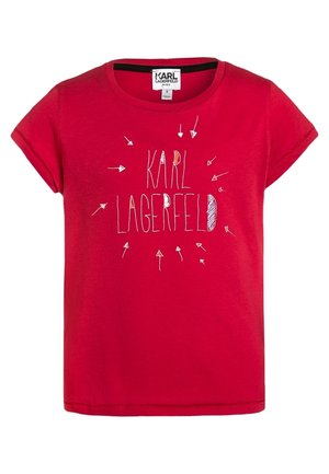 Czerwona koszulka dziecięca z krótkim rękawem z napisem "KARL LAGERFELD" w białym kolorze, otoczonym odręcznie narysowanymi białymi strzałkami z przodu.