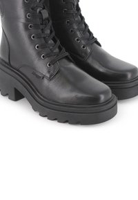 Botas de tobillo de cuero negro con cordones, suela de plataforma gruesa y patrón de adherencia robusto, con ojales de metal y cuello acolchado.
