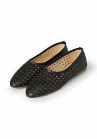 Zapatos planos negros con un diseño perforado, puntas redondeadas y un acabado de cuero suave. El interior es beige con una textura sutil.