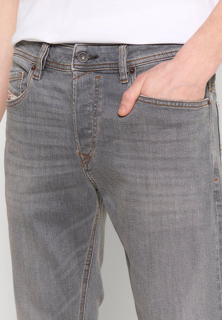 Grijze denim jeans met een klassieke pasvorm, voorzien van vijf zakken, oranje stiksels en een metalen knoopsluiting op de tailleband.