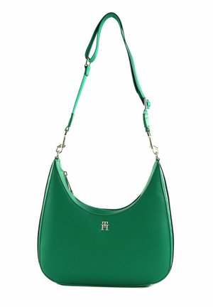 Grüne Leder-Schultertasche mit geschwungenem Design, ausgestattet mit einem silbernen Logo-Akzent und einem verstellbaren Tragegurt. Glatte Textur mit minimalistischem Design.