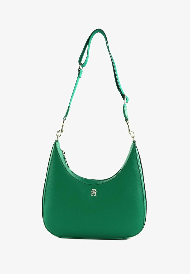 Grüne Leder-Schultertasche mit geschwungenem Design, ausgestattet mit einem silbernen Logo-Akzent und einem verstellbaren Tragegurt. Glatte Textur mit minimalistischem Design.