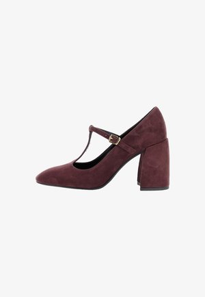 Scarpa elegante in suede bordeaux con tacco alto, design a T-strap, punta affusolata e tacco largo. Presenta una fibbia dorata per la regolazione.