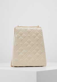 Borsa a tracolla color crema trapuntata con motivo geometrico, tracolla in catena color oro, design angolare e texture in faux pelle liscia.